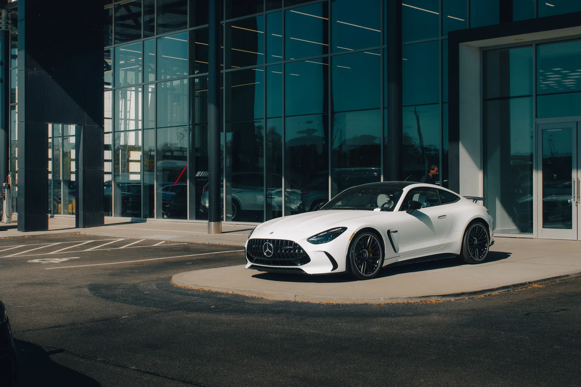 Mercedes sportive blanche devant une architecture contemporaine